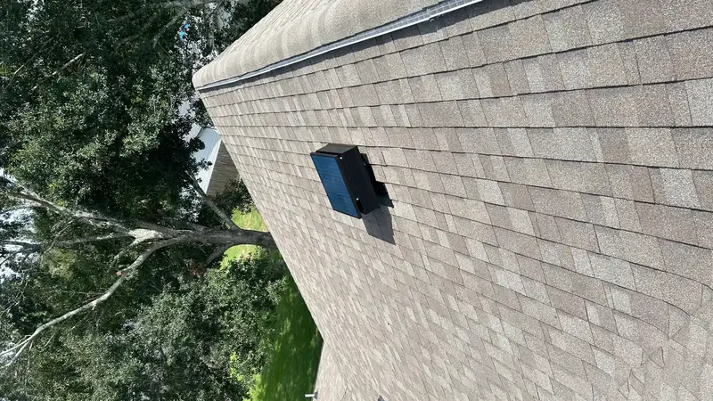 Solar attic fan installed high on a residential roof slope
